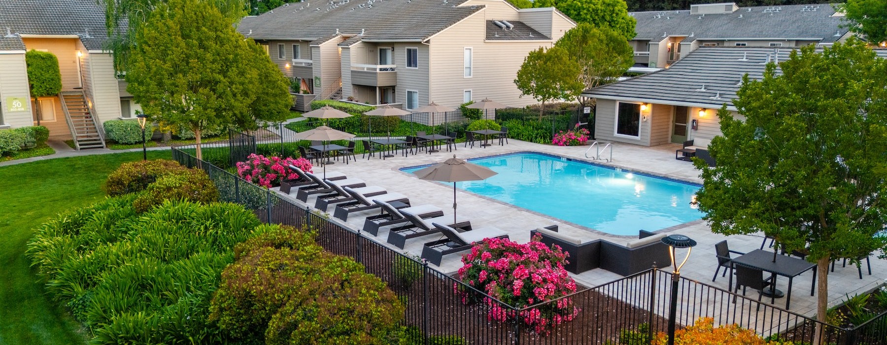 a swimming pool in a courtyard with lounge chairs